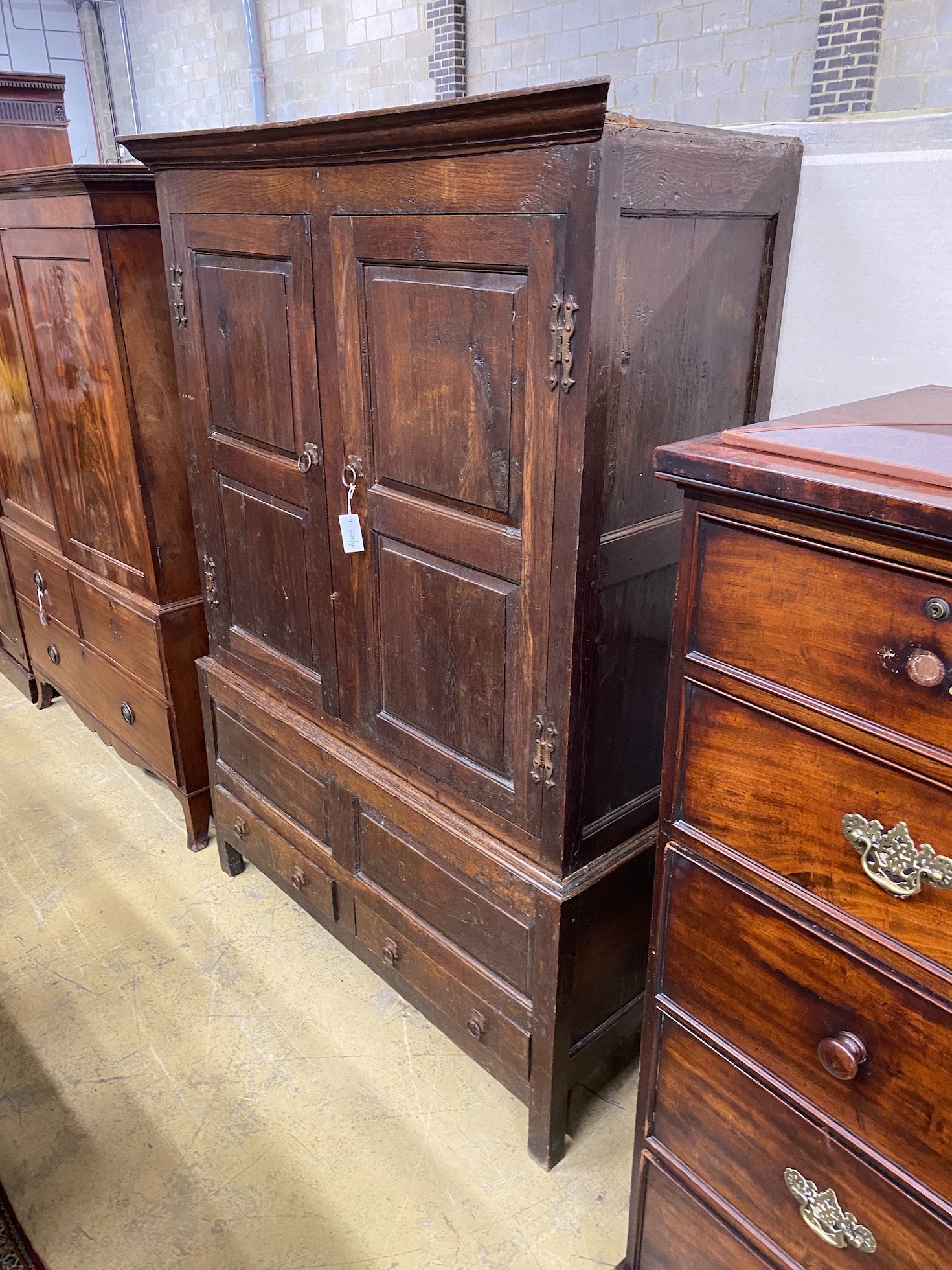 A mid 18th century oak press cupboard with two panelled doors and two drawers